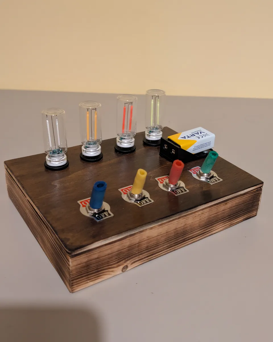 The Edison Edition with the lights off: stained wooden box, toggle switches with coloured caps and ON/OFF plates, clear glass bulbs
